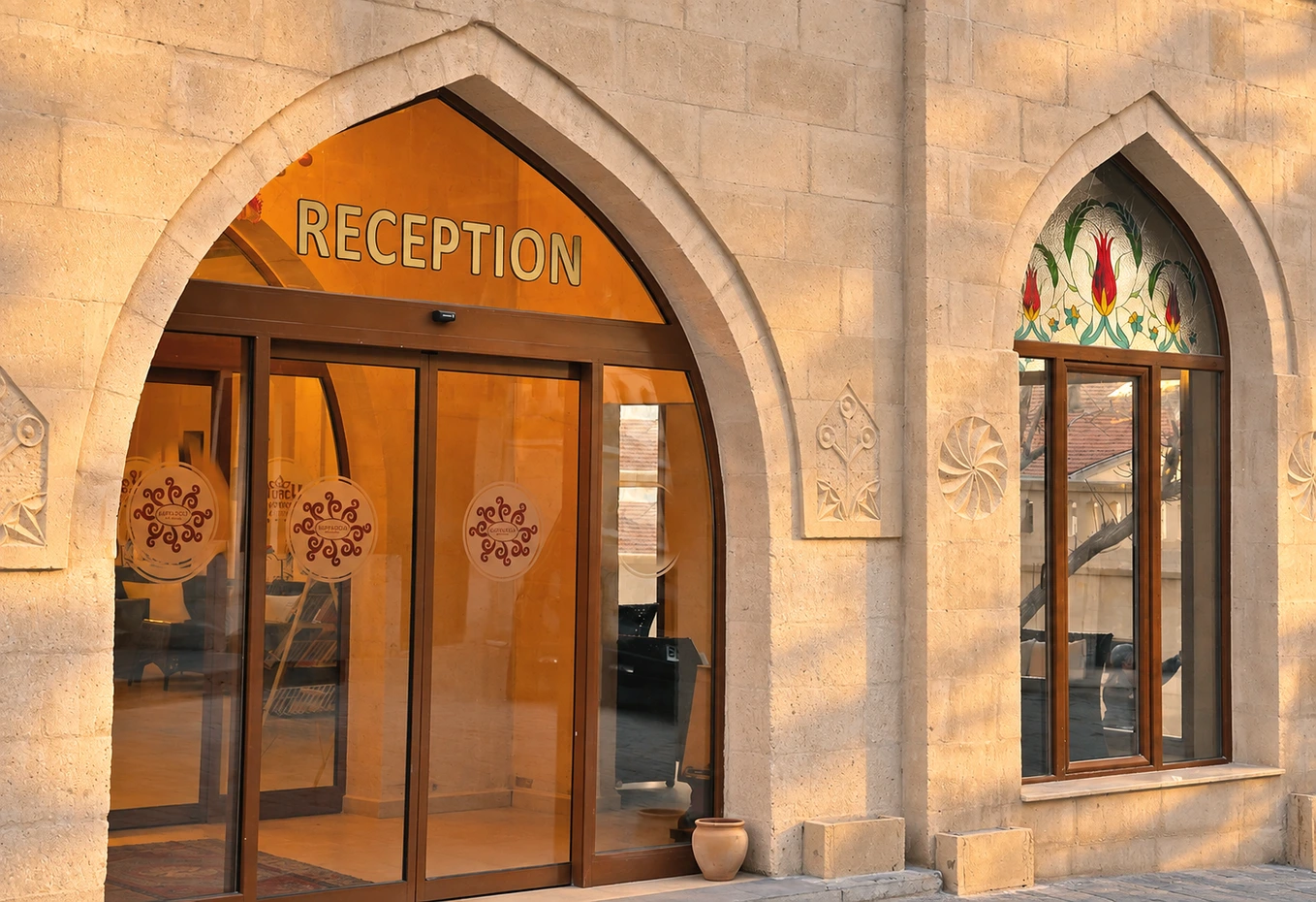 Stone arches, carved details, and a floral window at the reception entrance