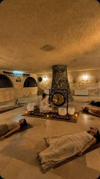 Sessione di rilassamento di gruppo con un gong in un ambiente in pietra