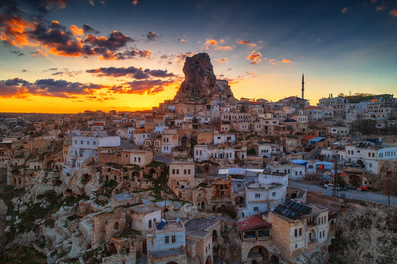 Ortahisar Castle and the stone houses of Cappadocia at sunset